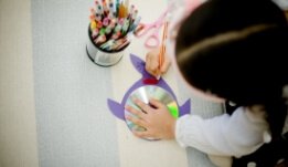 a little girl holding a pen and drawing